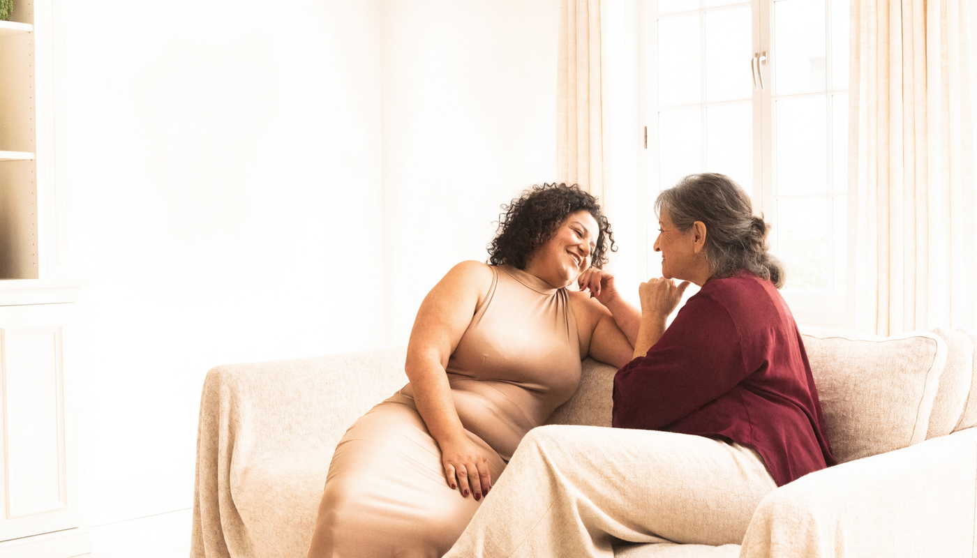 Deux femmes partageant un moment chaleureux sur un canapé en lin crème